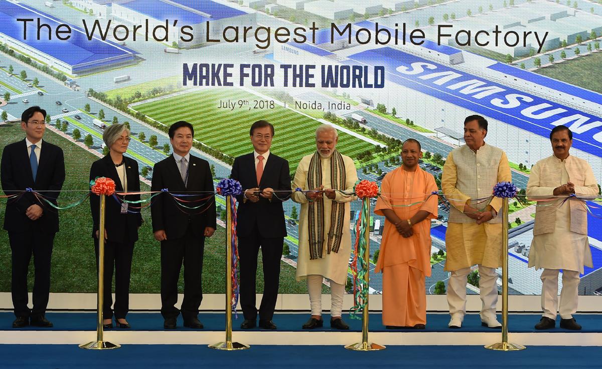 South Korea's President Moon Jae-in (4th L) and India's Prime Minister Narendra Modi (4th R) cut ribbons as Chief Minister of Uttar Pradesh state Yogi Adityanath (3rd R) looks on during the inauguration of the world's largest smartphone factory--an assembling plant that is an extension of an existing Samsung India facility--in Noida on July 9, 2018. (Money Sharma/AFP via Getty Images)