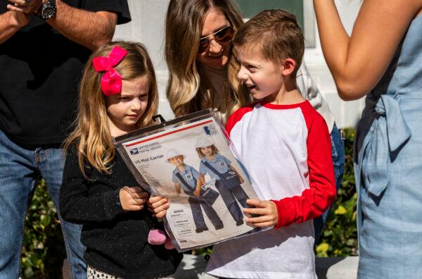 Seven-year-old Jacob Hayward receives gifts from his favorite mailman from the United States Postal Service, Van Singletary, at his home in Laguna Niguel, Calif., on Jan. 24, 2022. (John Fredricks/The Epoch Times)