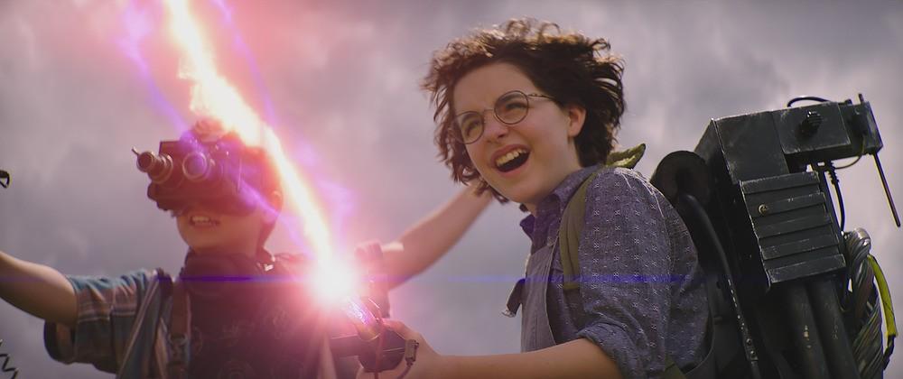 Podcast (Logan Kim) and Phoebe (Mckenna Grace) hose some ghosts with an old-school, DIY lightning bolt, in "Ghostbusters: Afterlife." (Columbia Pictures)