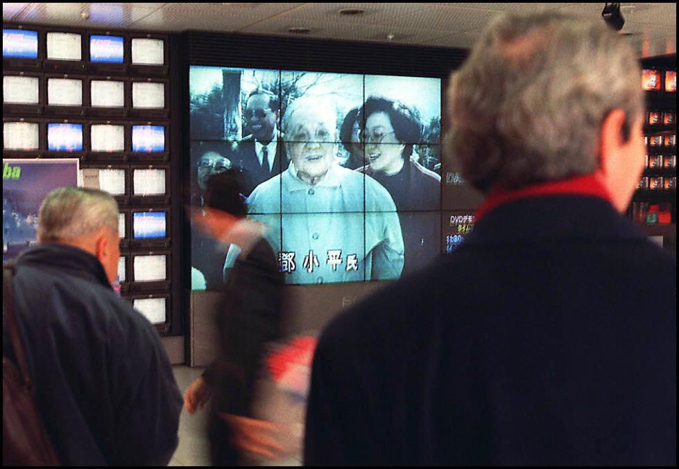 People watch a giant TV screen in the Sony showroom in Tokyo, showing a news programme on Feb. 20, 1997 reporting that then-Chinese leader Deng Xiaoping died on Feb. 19, aged 92. (Yoshikazu Tsuno/AFP via Getty Images)