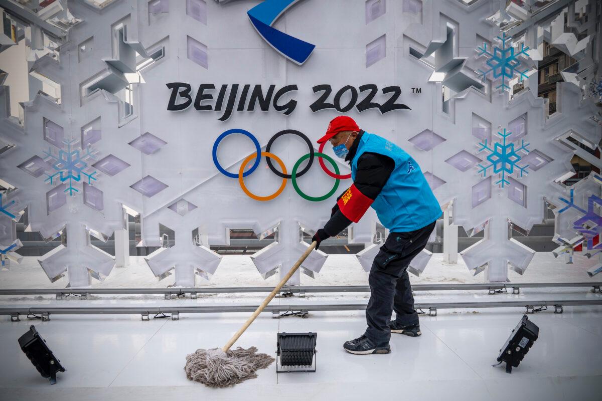 A volunteer cleans a sculpture about Beijing 2022 Winter Olympics in Beijing, China, on Jan. 23, 2022. (Andrea Verdelli/Getty Images)
