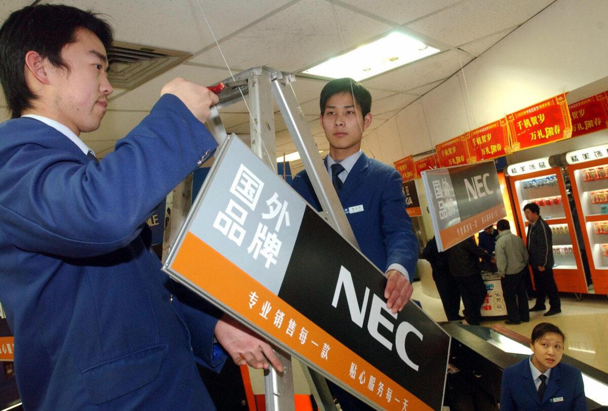 Workers at a department store take down signs of Japanese products after pulling goods off the shelf, 31 March 2005, in central China's Henan province, after nearly 30 chain stores in northeast China's Shenyang city also pulled Japanese products off their shelves following Chinese media reports saying some of the companies supported revisionist history textbooks. (AFP via Getty Images)