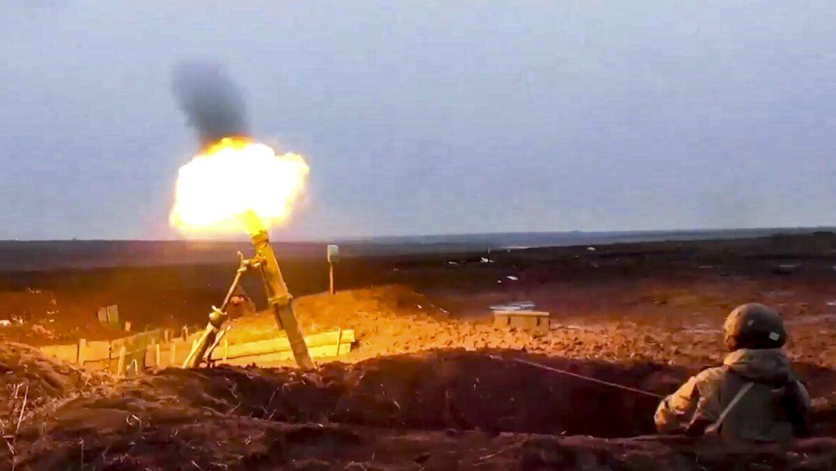 In this photo taken from a video provided by the Russian Defense Ministry Press Service on Jan. 25, 2022, a Russian soldier fires a mortar as he attends a military exercise at a training ground in Russia. (Russian Defense Ministry Press Service via AP)