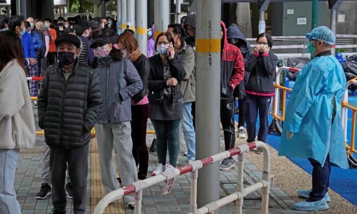 Residents line up to get tested for the coronavirus in a lockdown area in Kwai Chung Estate, Hong Kong, on Jan. 22, 2022. (Kin Cheung/AP Photo)