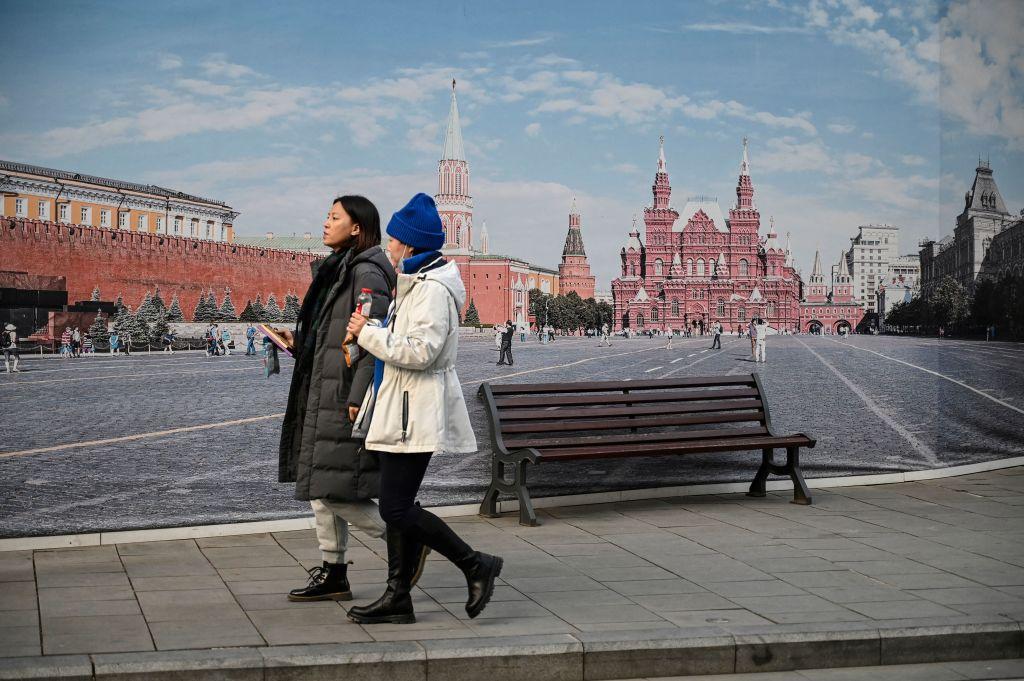 People walk past a wall decorated with a mural of Moscow's Red Square, in Beijing on Dec. 8, 2021. (Jade Gao/AFP via Getty Images)