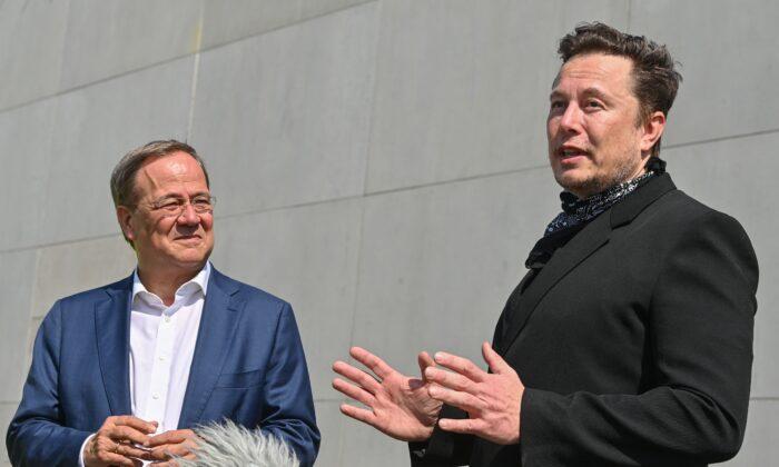 North Rhine-Westphalia's State Premier, Christian Democratic Union (CDU) leader and candidate for Chancellor Armin Laschet (L) and U.S. entrepreneur and business magnate Elon Musk talk with journalists as they visit the Tesla Gigafactory plant under construction in Gruenheide near Berlin, eastern Germany, on August 13, 2021. (Patrick Pleul/Pool/AFP via Getty Images)