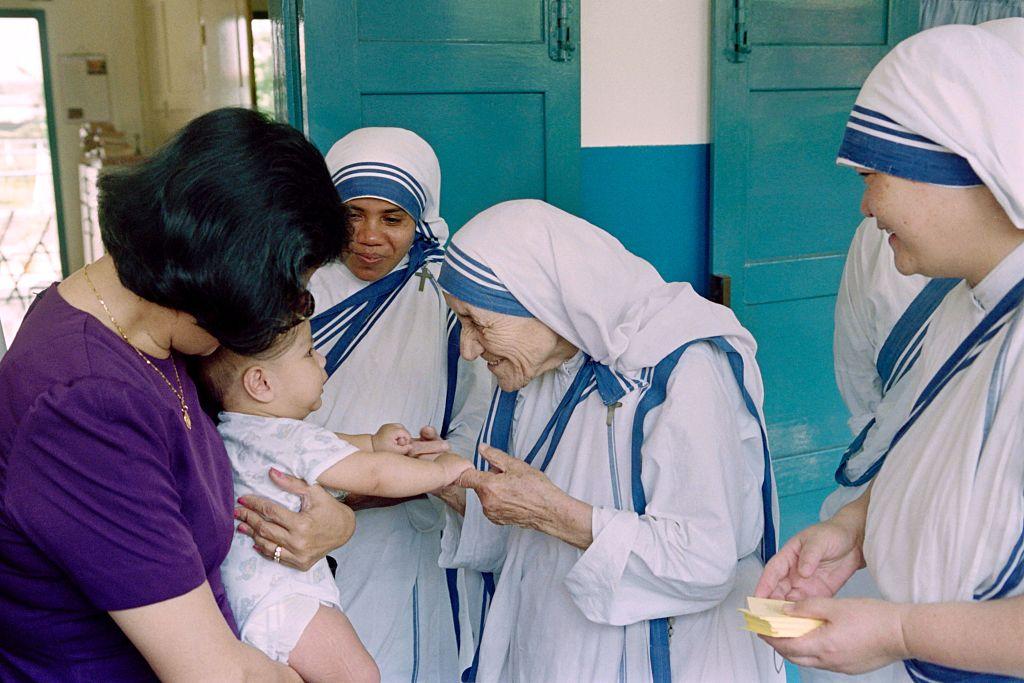 Mother Teresa (R) gives her blessing to a child at the Gift of Love Home on Oct. 20, 1993, in Singapore. (ROSLAN RAHMAN/AFP via Getty Images)