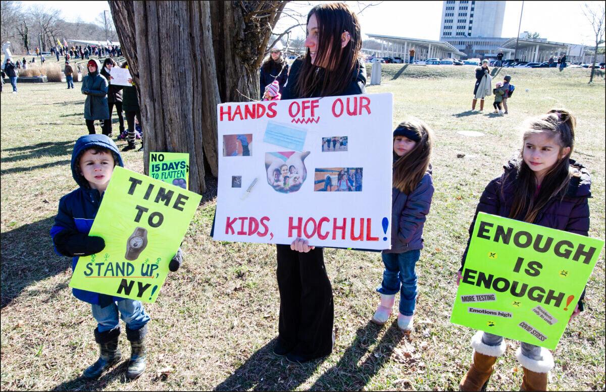 A mother and her children at a Long Island Loud Majority protest against state-mandated masks for school children at the Suffolk County government offices, in New York, on Jan. 26, 2022. (Dave Paone/The Epoch Times)