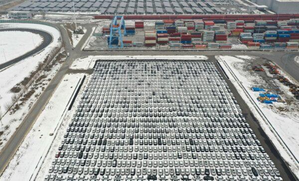 Cars line up surrounded by recent snow next to shipping containers (top) at a BMW factory in Shenyang in northeastern China's Liaoning Province on Nov. 17, 2021. (STR/AFP via Getty Images)