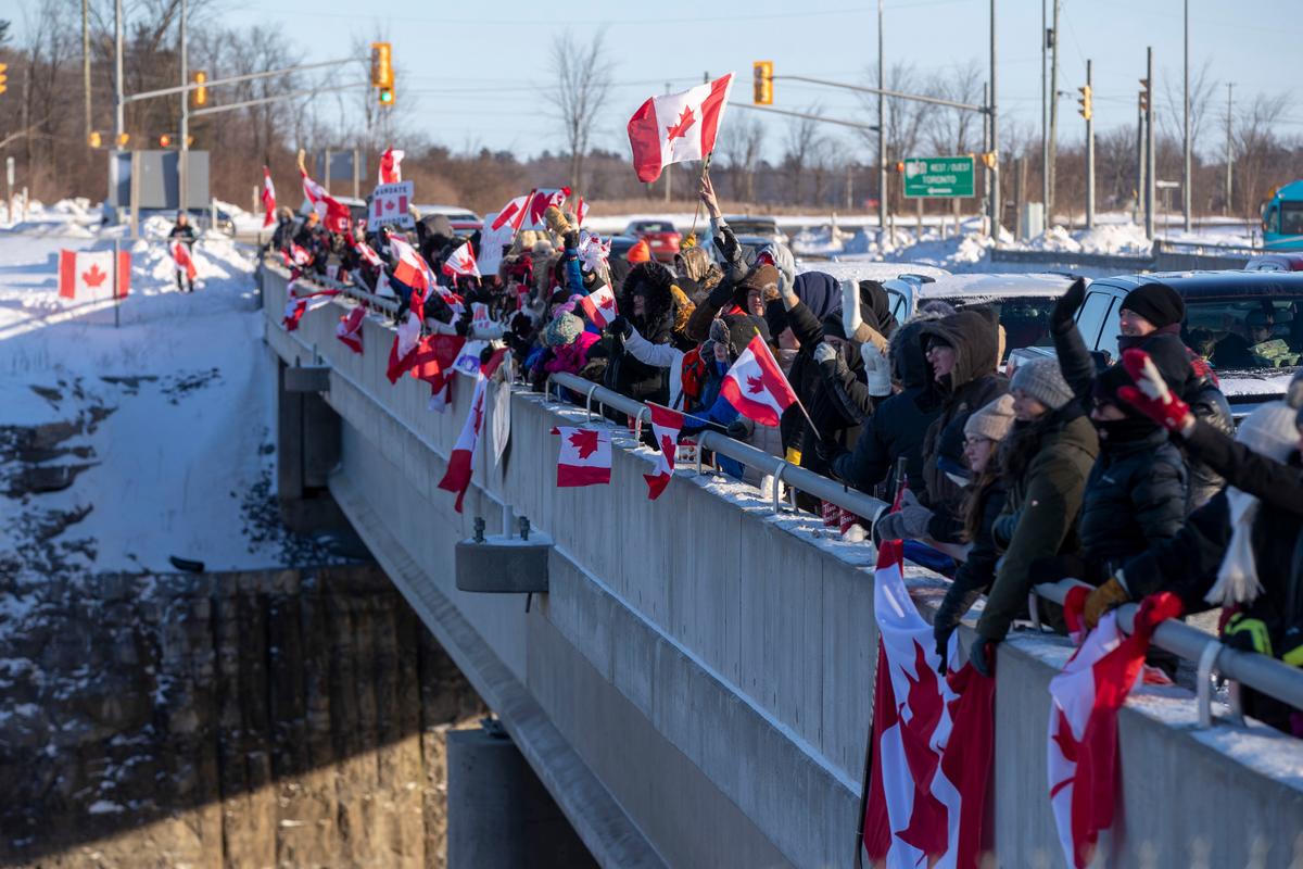 Supporters cheer on truck drivers in the "Freedom” convoy headed for Ottawa from an overpass in Kingston, Ontario, on Jan. 28, 2022. (Lars Hagberg/The Canadian Press)