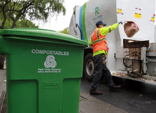 A worker throws a bag of compostable material into his truck on Dec. 10, 2010, in San Francisco. (Justin Sullivan/Getty Images)