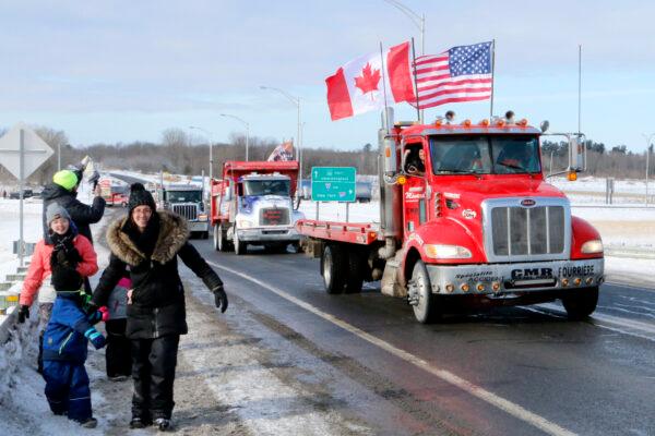 Trucks participating in the "Freedom Convoy" depart an area south of Montreal on Jan. 28, 2022. (Noé Chartier/The Epoch Times)