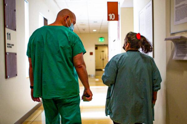 Hospital staff members walk down a hallway at the University of California–Irvine Medical Center in Orange, Calif., on Dec. 16, 2020. (John Fredricks/The Epoch Times)