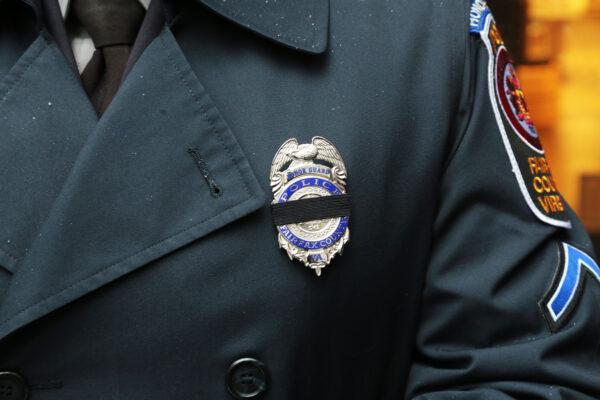 Police officers wore ribbons across their badges as a sign of respect for Jason Rivera, the young officer killed in the line of duty on Jan 21, 2022. Thousands of colleagues turned out for the service on Jan. 28, 2022. (Richard Moore/The Epoch Times)