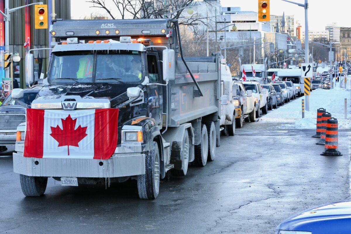 Trucks and other vehicles drive through Ottawa as part of the trucker convoy protesting COVID-19 restrictions and mandates on Jan. 29, 2022. (Jonathan Ren/The Epoch Times)