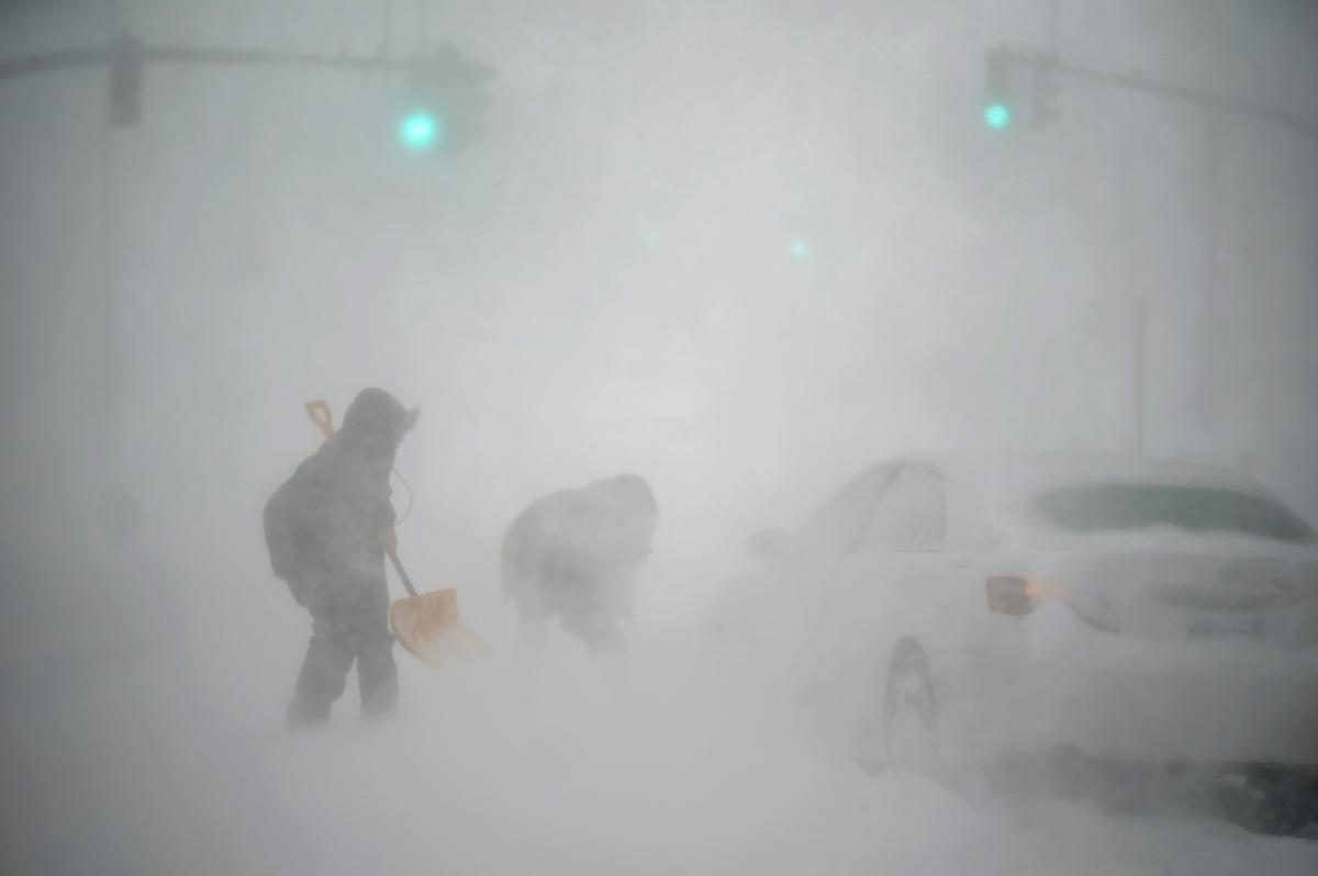 A stranded motorist (R), gets help shoveling out his car from a passerby with a shovel in Providence, R.I., on Jan. 29, 2022. (David Goldman/AP Photo)