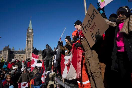 Protesters participating in a cross-country truck convoy protesting measures taken by authorities to curb the spread of COVID-19 and vaccine mandates gather near Parliament Hill in Ottawa, on Jan. 29, 2022. (Adrian Wyld/The Canadian Press via AP)