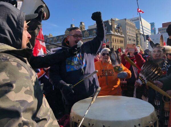  Protesters participating in the truck convoy protest against COVID-19 mandates and restrictions perform with a traditional First Nations drum on Parliament Hill on Jan. 29, 2022. (Noé Chartier/The Epoch Times)