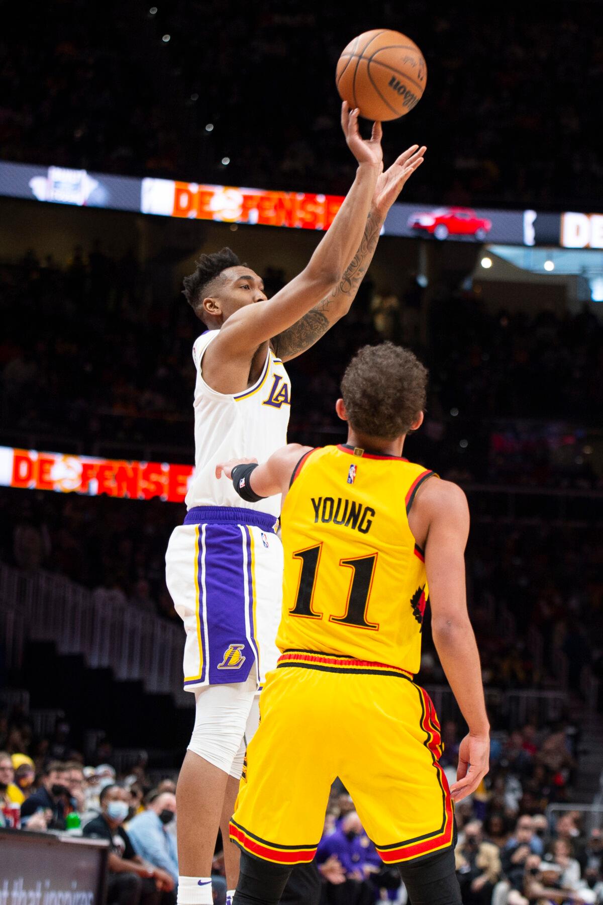 Los Angeles Lakers guard Malik Monk, left, shoots a 3-point basket over Atlanta Hawks guard Trae Young, right, during the second half of an NBA basketball game in Atlanta on Jan. 30, 2022. (Hakim Wright Sr./AP Photo)