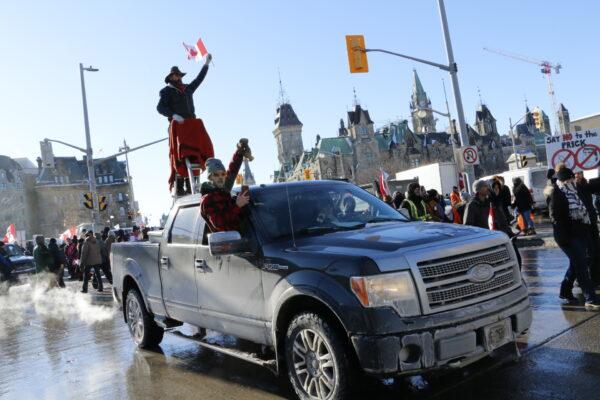  A protester rides on top of a ladder in the back of a pick-up truck during the freedom protest in Ottawa on Jan. 29, 2022. (Noé Chartier/The Epoch Times)