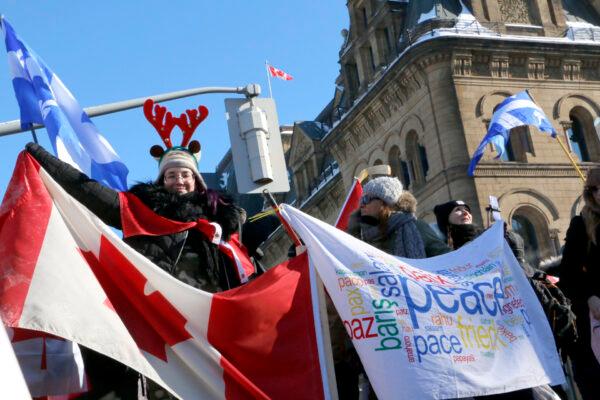  Protesters hold flags and banners in front of Parliament Hill in Ottawa on Jan. 29, 22022. (Noé Chartier/The Epoch Times)