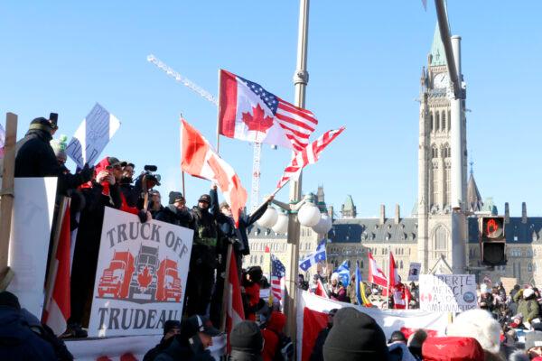  Protesters wave flags and hold banners in front of Parliament Hill in Ottawa on Jan. 29, 2022. (Noé Chartier/The Epoch Times)