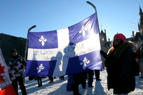  Protesters hold a Quebec flag upside down as a signal of a nation in distress on Parliament Hill in Ottawa on Jan. 29, 2022. (Noé Chartier/The Epoch Times)