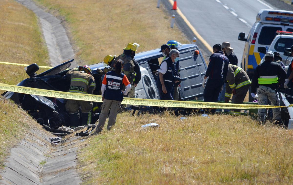 An emergency crew works next to a damaged vehicle at the site of an accident after a van overturned and flipped into a ditch on a highway in central Mexico, near the city of Lagos de Moreno, Mexico, on Jan. 29, 2022. (Liberto Urena/Reuters)