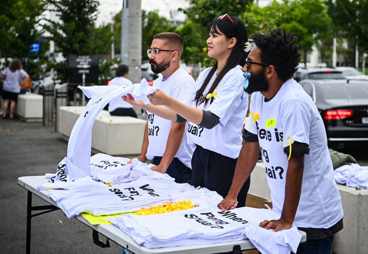 Activists hand out t-shirts reading "Where is Peng Shuai?" to spectators outside Melbourne Park ahead of the women's singles final, in Melbourne Park, Melbourne, Australia, on Jan. 29, 2022. (Morgan Sette/Reuters)