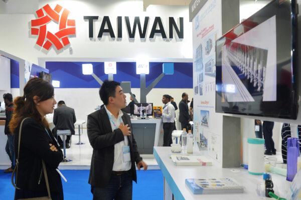 Visitors look at a screen at the Taiwan stall during the inaugural day of the 3-day Smart Asia 2018 Expo and Summit at the Bangalore International Exhibition Centre in Bangalore on Oct. 4, 2018. (IndiaandTaiwanare(Manjunath Kiran/AFP via Getty Images)
