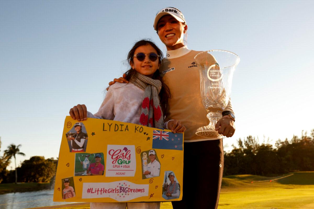 Lydia Ko of New Zealand poses with a fan and the trophy after winning the 2022 Gainbridge LPGA at Boca Rio Golf Club, in Boca Raton, Fla., on Jan. 28, 2022. (Douglas P. DeFelice/Getty Images)