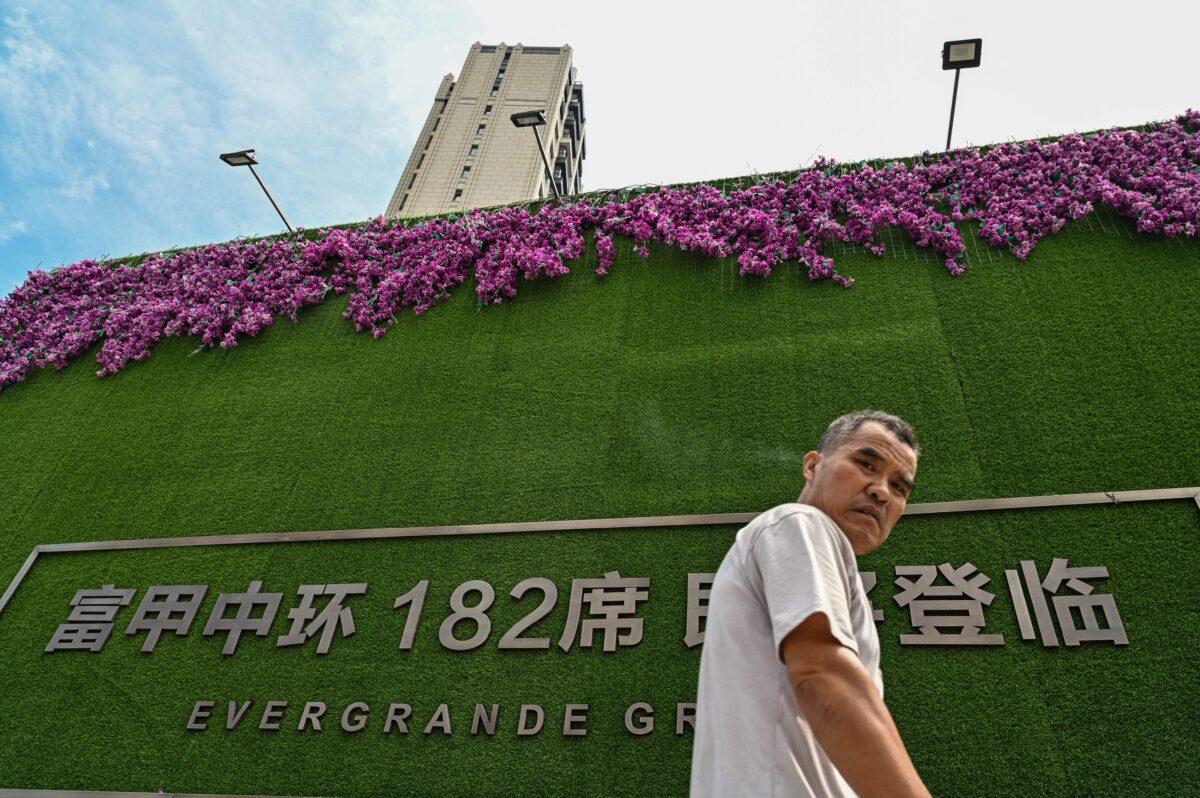 A man walks past a residential building developed by Evergrande in Shanghai on Sept. 24, 2021. (Hector Retamal/AFP via Getty Images)