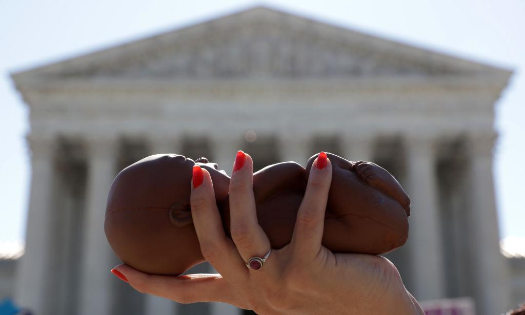 A pro-life activist holds a model fetus during a demonstration in front of the U.S. Supreme Court in Washington on June 29, 2020. (Alex Wong/Getty Images)