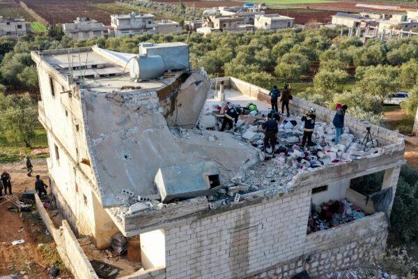 People inspect a destroyed house following an operation by the U.S. military in the Syrian village of Atmeh, in Idlib province, Syria, on Feb. 3, 2022. (Ghaith Alsayed/AP Photo)