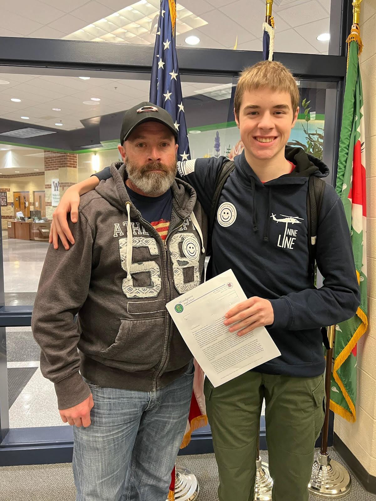 Jarod Missler (R), with his suspension letter and father, Andrew Missler, at Woodgrove High School in Purcellville, Va., on Feb. 2, 2022. (Courtesy of Andrew Missler)