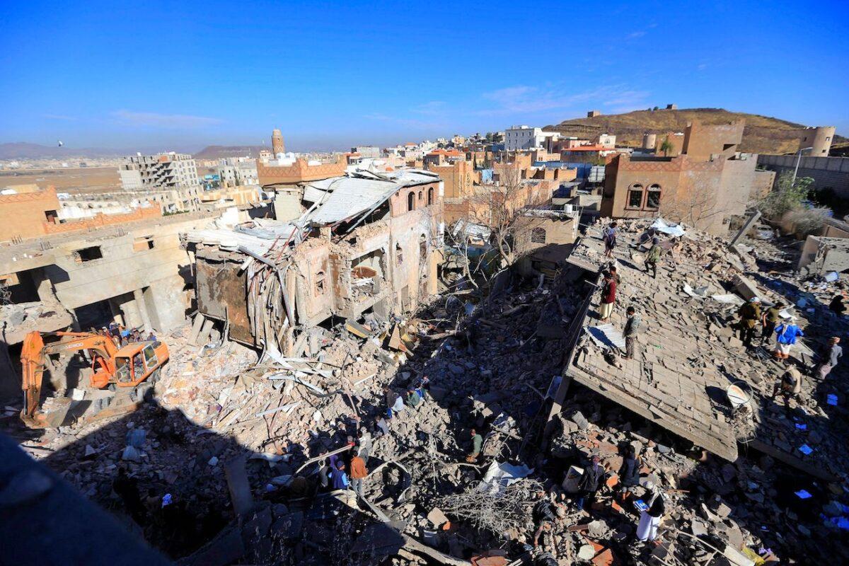 Yemenis inspect the damage following overnight air strikes by the Saudi-led coalition targeting the Houthi rebel-held capital Sanaa, on Jan. 18, 2022. (Mohammed Huwais/AFP via Getty Images)