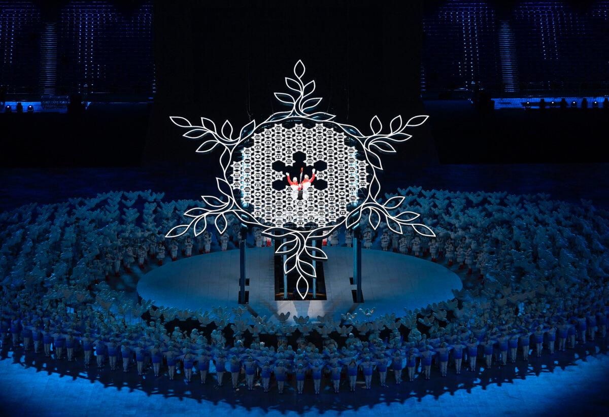 Torchbearers Zhao Jiawen and Dinigeer Yilamujiang hold the Olympic torch during the opening ceremony of the Winter Olympics at the National Stadium in Beijing on Feb. 4, 2022. (Toby Melville/Reuters)