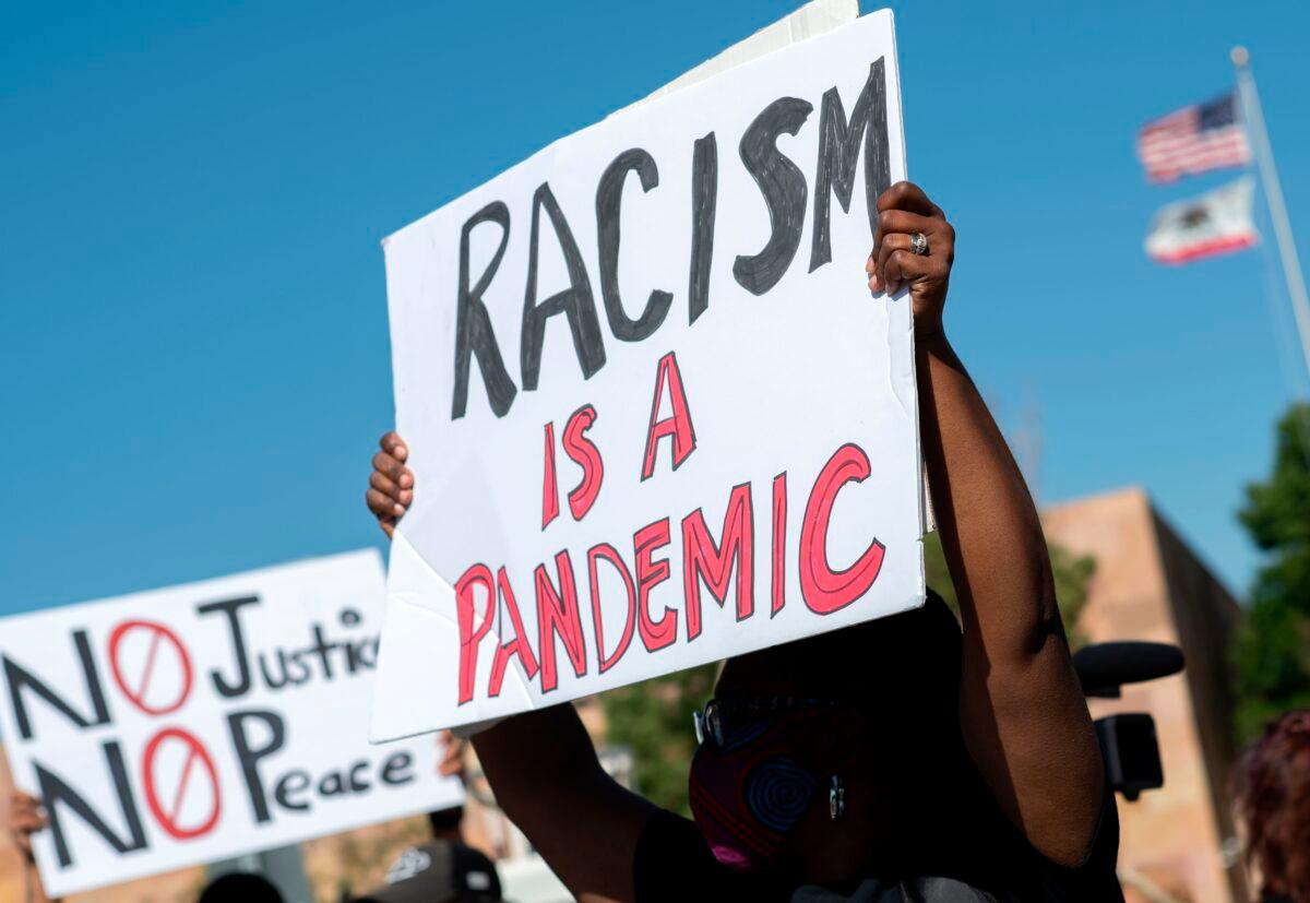 A woman holds up a placard during a protest in Victorville, Calif., on June 16, 2020. (Valerie Macon/AFP via Getty Images)