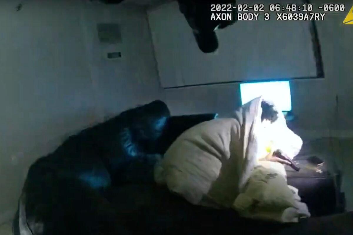 In this image taken from Minneapolis Police Department body camera video and released by the city of Minneapolis, 22-year-old Amir Locke wrapped in a blanket on a couch holding a gun moments before he was fatally shot by Minneapolis police as they were executing a search warrant in a homicide investigation in Minneapolis on Feb. 2, 2022. (Minneapolis Police Department via AP)
