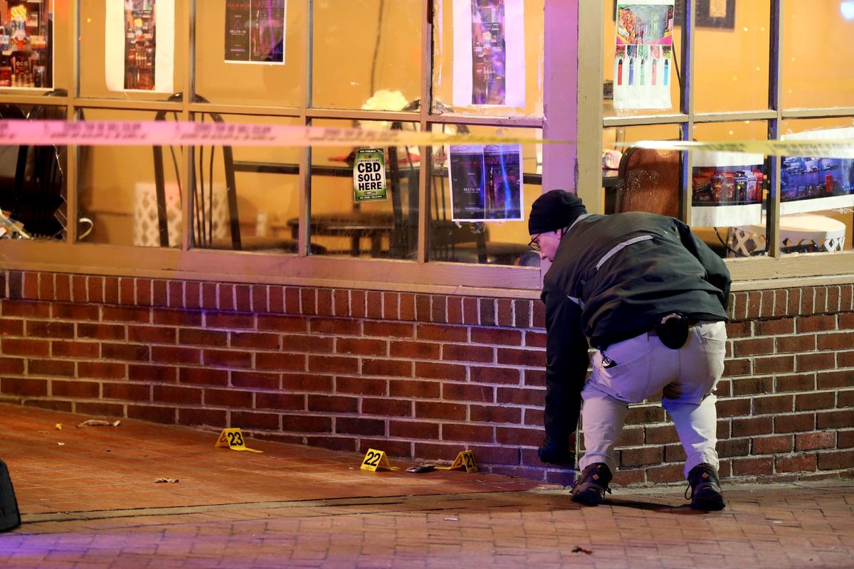 A police officer conducts an investigation after a shooting at Melody Hookah Lounge on Main Street in Blacksburg, Va., on Feb. 5 2022. (Matt Gentry/The Roanoke Times via AP)