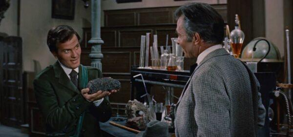  Alec McEwan (Pat Boone, L) has a mysterious goodie for Sir Oliver S. Lindenbrook (James Mason). (20th Century Fox)