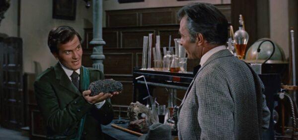 Alec McEwan (Pat Boone, L) has a mysterious goodie for Sir Oliver S. Lindenbrook (James Mason). (20th Century Fox)