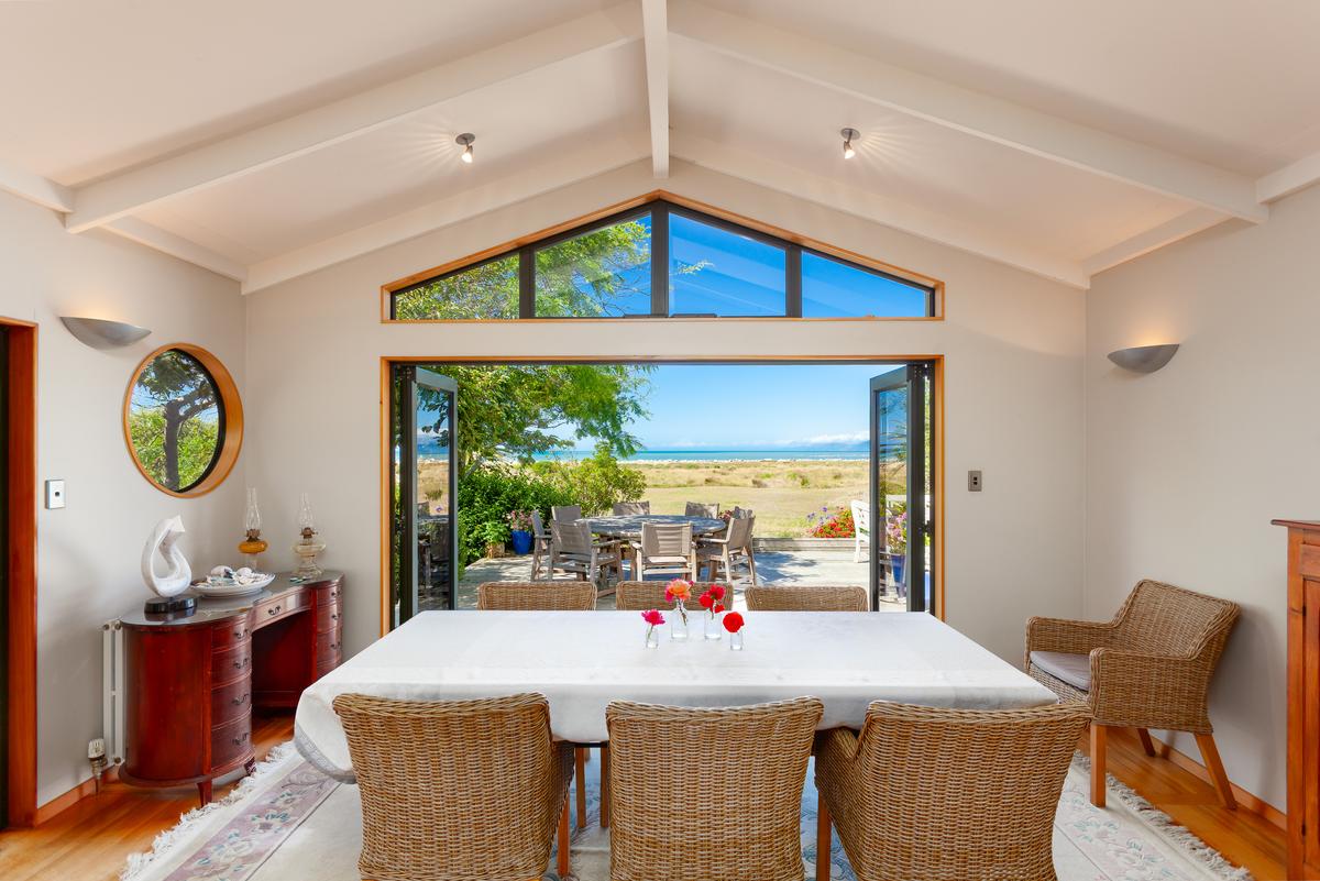 The charm and simplicity of the home are carried over into the dining room, which looks out over the Tasman Sea. (New Zealand Sotheby’s International Realty)