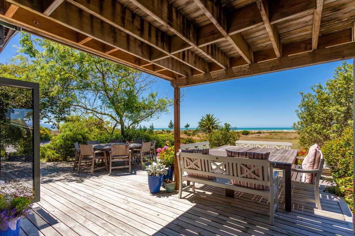 The property’s shaded and covered decks connect the breezy interior of the main house with the pool, the leisure areas, and gardens, and with the amazing beach just over the dunes. (New Zealand Sotheby’s International Realty)
