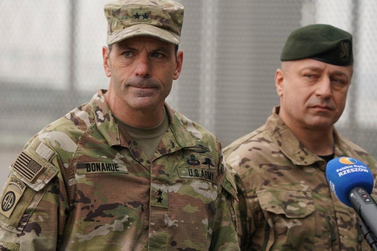 U.S. Army General Christopher Donahue (L), commanding general of the 82nd Airborne Division, and Polish General Wojciech Marchwica speak to journalists after unloading vehicles from a transport plane arriving from Fort Bragg at the Rzeszow-Jasionka airport in southeastern Poland on Feb. 6, 2022. (AP Photo)