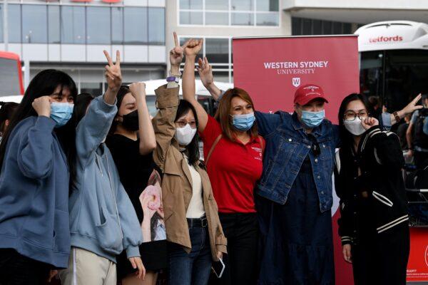 International students pose for a photograph with university representatives after arriving at Sydney Airport in Sydney, Australia, on Dec. 6, 2021. (AAP Image/Bianca De Marchi)