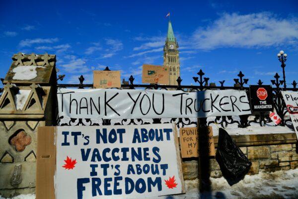 Signs by Parliament in Ottawa as demonstrations against COVID-19 mandates and restrictions continue, on Feb. 7, 2022. (Jonathan Ren/The Epoch Times)