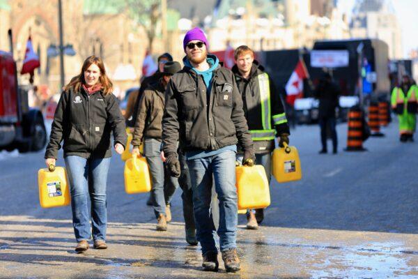  Protesters walk around with empty fuel containers after police threatened arrest for bringing fuel to the protest site, on Feb. 7, 2022. (Jonathan Ren/The Epoch Times)