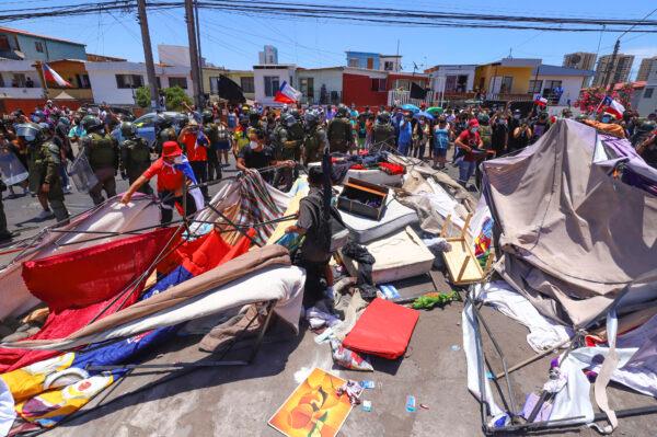 People destroy a makeshift camp of migrants during a protest against the increase of crime, which they claim is due to the presence of immigrants, in Iquique, Chile, on Jan. 30, 2022. (Fernando Munoz/AFP via Getty Images)