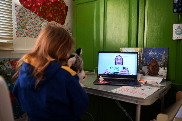 Five-year-old Lois Copley-Jones watches an online phonics lesson on a laptop in her bedroom in Newcastle, England, on Jan. 6, 2021. (Gareth Copley/Getty Images)